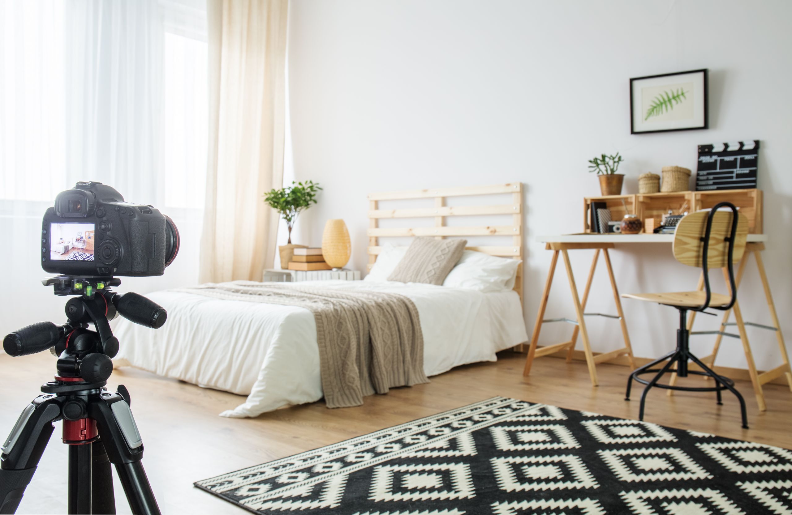 Camera on a tripod in modern bedroom interior